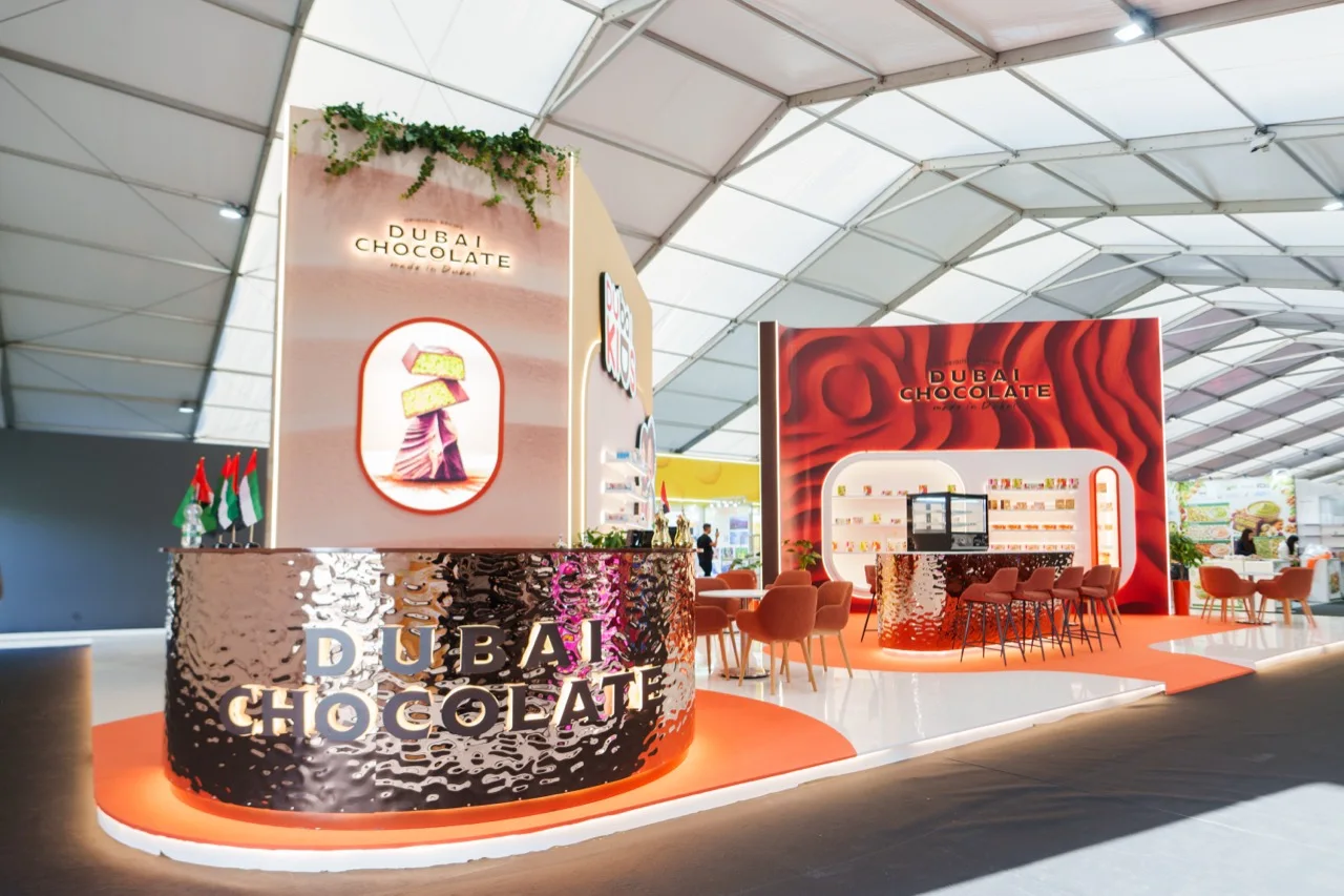The Katrina Dubai Chocolate stand at SIAL Paris, with a reflective reception counter and red chocolate display