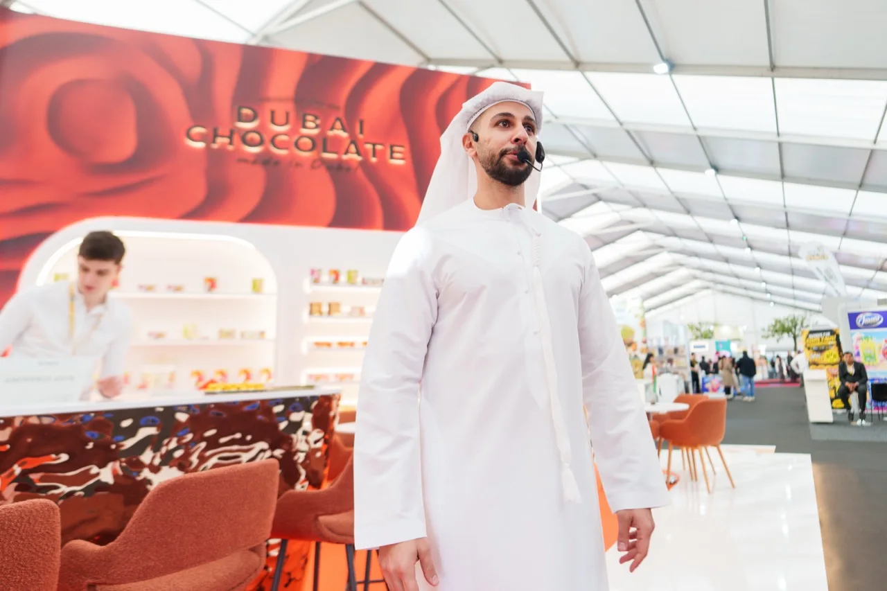 A presenter wearing a headset at the Katrina Dubai Chocolate stand